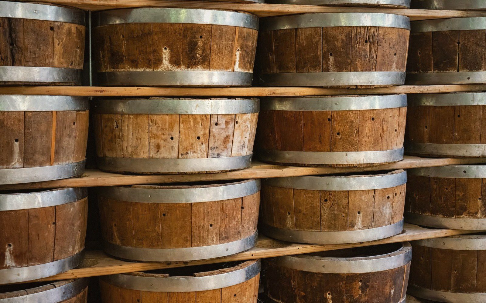 Wooden foeders with metal bands stacked on shelves in rows